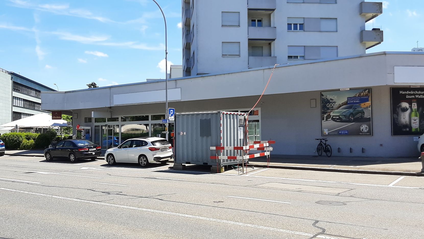 Ein geschlossener Container auf einem Parkplatz entlang einer Strasse.